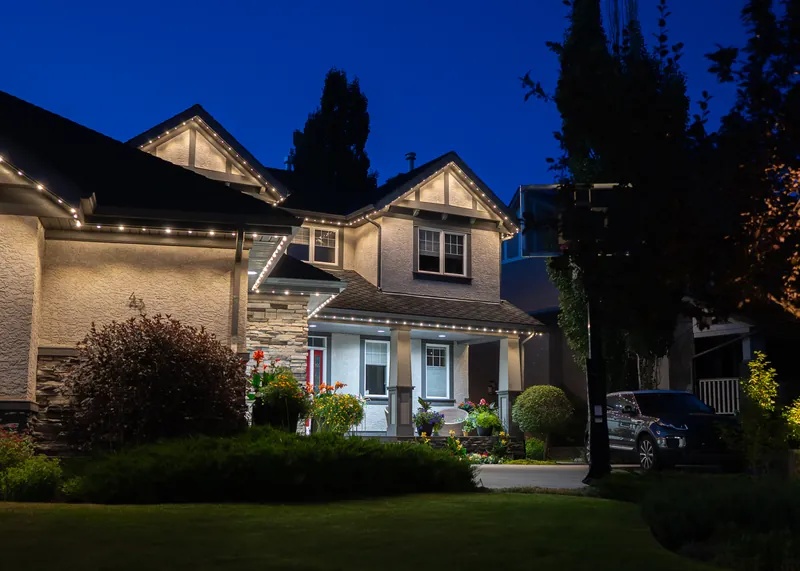 Warm lighting over a landscaped front entry at dusk