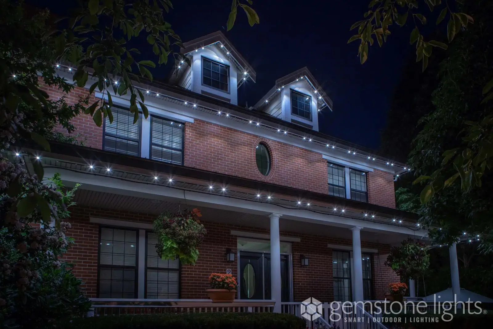 Brick home with a columned porch in warm white light