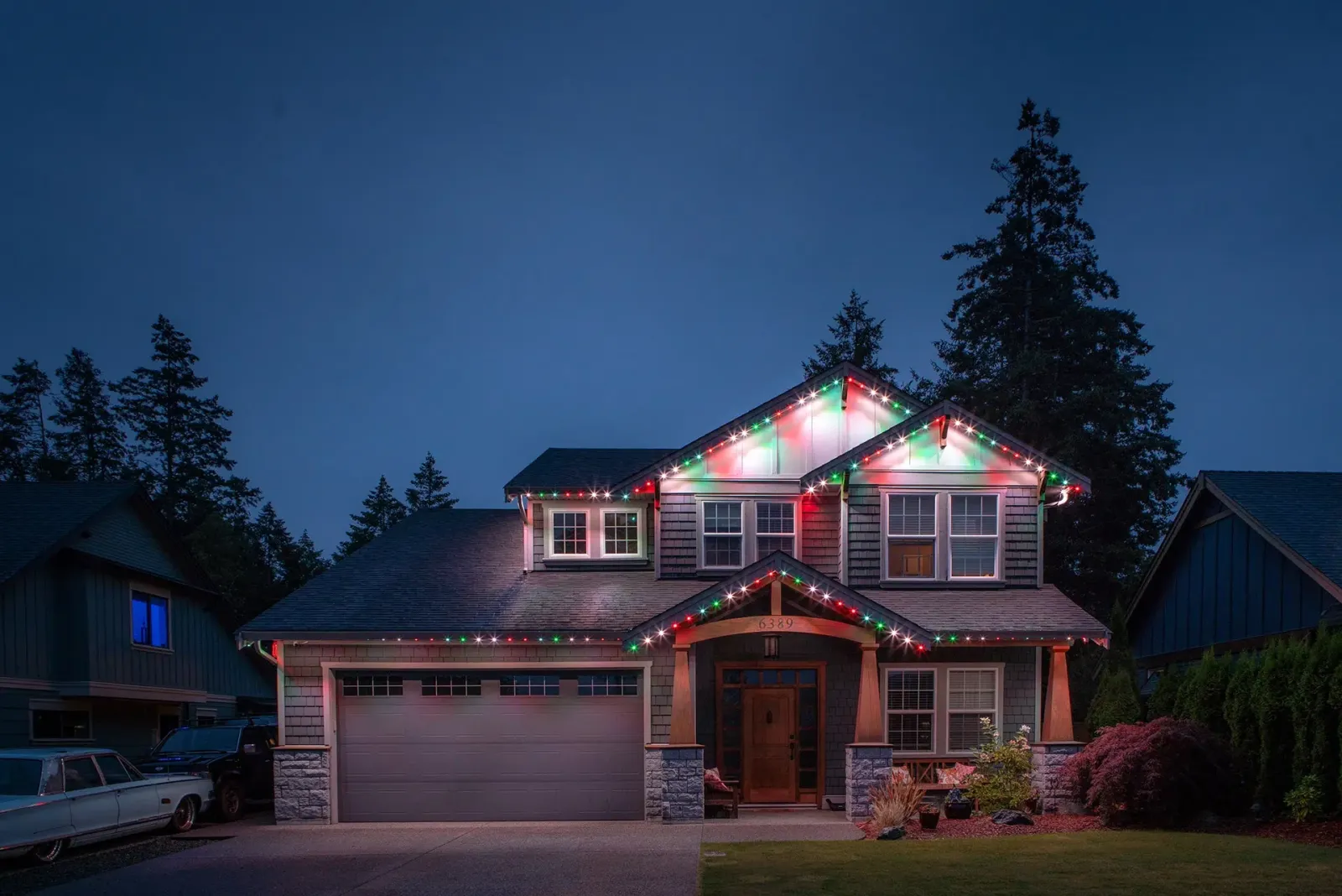 Craftsman house outlined in red, green and white Christmas lights